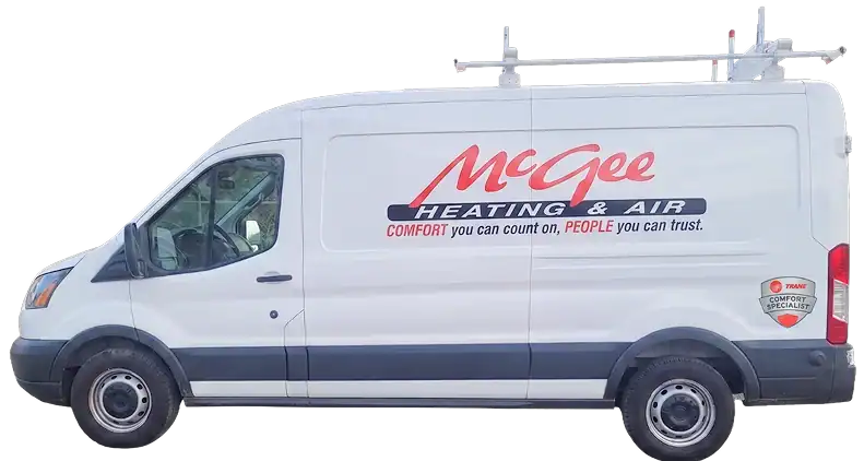 White McGee Heating & Air service van with company logo, slogan, and ladder rack on roof, parked on a white background.